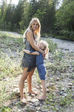 Mother and her little daughter hugging together in nature