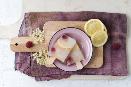 Homemade elderflower lemon raspberry ice lollies in bowl