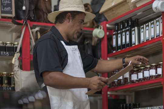 Shopkeeper in shop taking stock