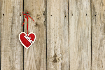 Red heart with Believe hanging on wood background