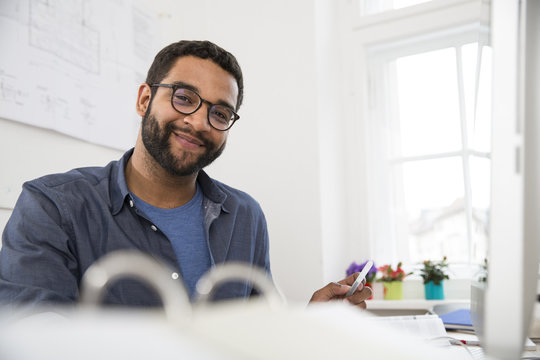 Portrait of smiling man at desk in office