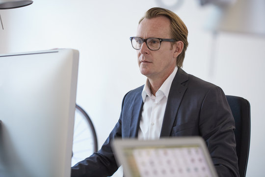 Portrait of businessman with glasses working at computer