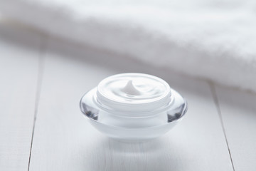 Cosmetic cream white organic beauty moisturizer cleansing acne product with towel on white background. Dermatology hygienic anti aging, wrinkles, blemish, pimples, blackheads clear treatment