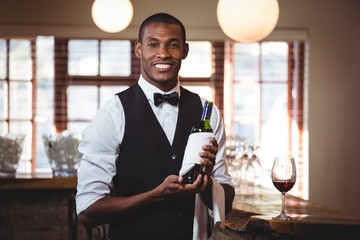 Portrait of bartender holding a wine bottle 