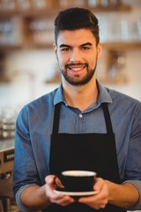 Portrait of smiling man holding cup of coffee