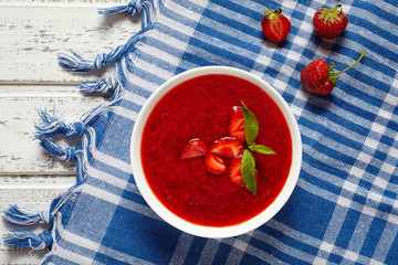 Fresh strawberry cream soup vegetarian cold sweet berry smoothie summer food on white wooden background table