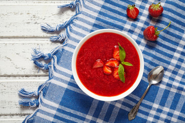 Fresh organic strawberry cream soup vegetarian cold sweet berry smoothie summer food on white wooden background table