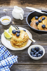 Healthy breakfast classic. Several domestic hot pancakes with fresh ripe blueberry lime zest, honey