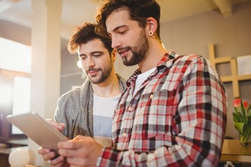 Graphic designer using digital tablet with his coworker