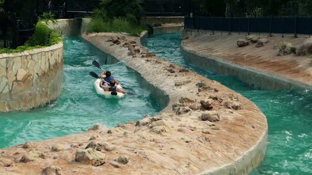 Aquapark. Tourists in canoe on extreme rafting in artificial waves of rowing . Tourism, travel journey trip voyage.