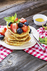 Delicious pancakes with berries on wooden background