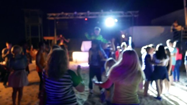 Celebration, holiday, feast. Night Beach Disco with illumination, concert. Dancing people and children  with fun gladness on the discotheque entertainment. Gaiety merriment joyfulness of teens