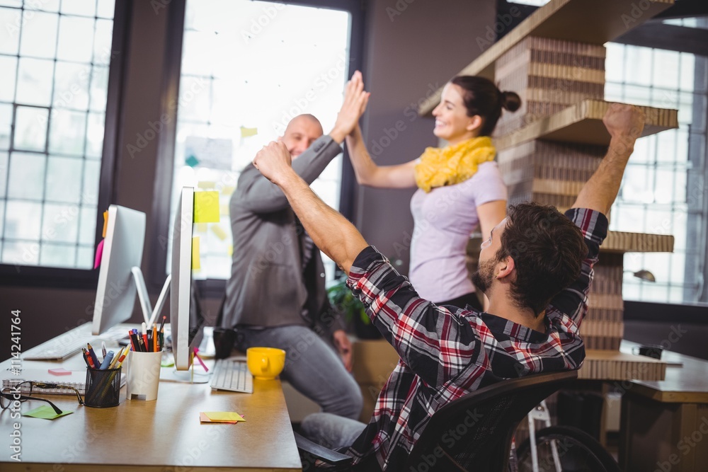 Wall mural Business people cheering at computer desk