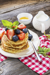 Delicious pancakes with berries on wooden background