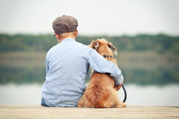 freundschaftliche Umarmung eines Jungen mit seinem Hund