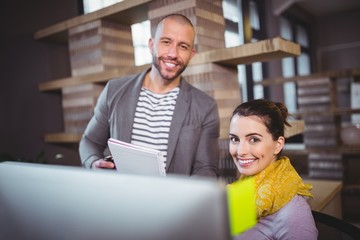 Happy colleagues working at computer desk