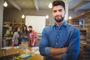 Fototapeta premium Confident creative businessman standing with arms crossed 