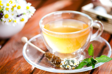 Cup of tea on a wooden backgound. Flowers and grass. Natural background. Agricultural.Garden