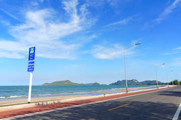 Coastal asphalt road with the bicycle lane and cloudy blue sky at Hua Hin, Southern Thailand.
