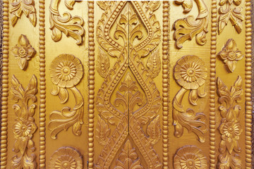 Fototapeta na wymiar Wood carving on the wall in Myanmar. Myanmar carving on golden wall.