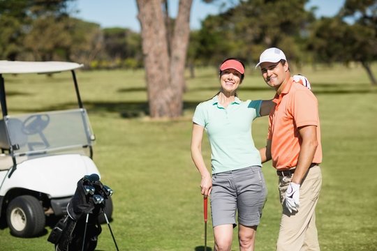 Portrait of smart golfer couple with arm around