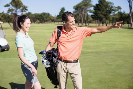 Golfer pointing while standing by woman