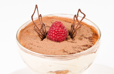 Chocolate tiramisu with berries in a glass on a white background, traditional italian cuisine, close up