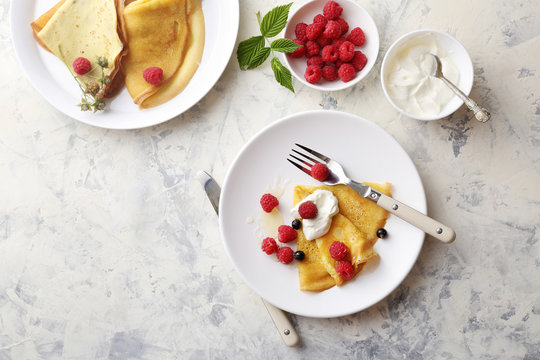 golden crepe with raspberry on white plate