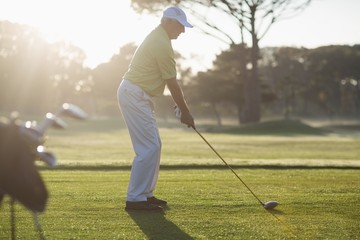 Full length side view of mature man playing golf