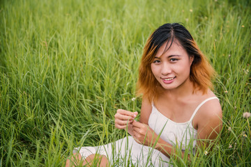 woman with flower sit on green grass background