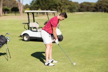 Side view of young man playing golf 