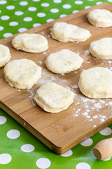 Domestic homemade raw dough with flour on the wooden board