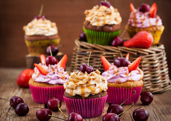 Delicious cupcakes decorated with caramel and fresh berries