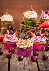 Delicious cupcakes decorated with caramel and fresh berries