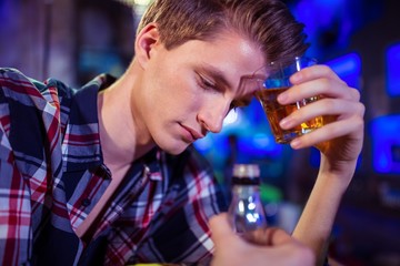 Sad man holding whiskey glass