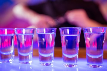 Shot glasses on illuminated bar counter