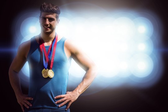 Composite image of portrait of athletic man holding medals