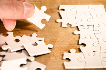 fill the gaps, white jigsaw/puzzle whit one gap, over  black wooden table background, symbol of...