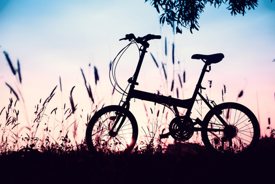 beautiful landscape image with silhouette Bicycle at sunset in v