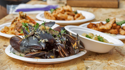 plate with street food mussels and other dishes outdoor