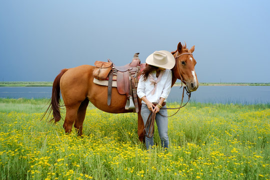 Woman wearing cowboy hat with horse