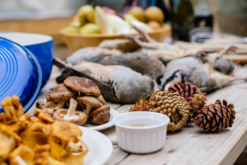 Game birds and mushrooms on wooden table