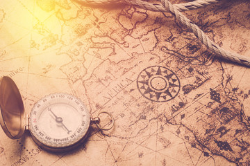Fototapeta na wymiar Vintage compass and rope on old maps