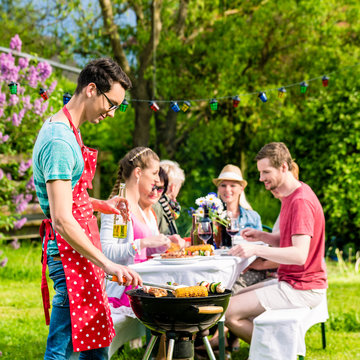 Familie und Freunde beim Grillen auf Garten Party
