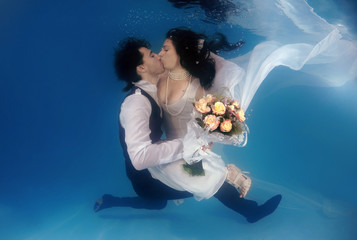 Bride and groom, underwater wedding in a pool