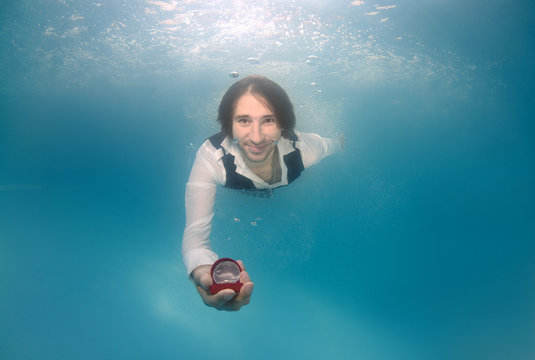 Groom Presenting Ring, Underwater Wedding In Pool