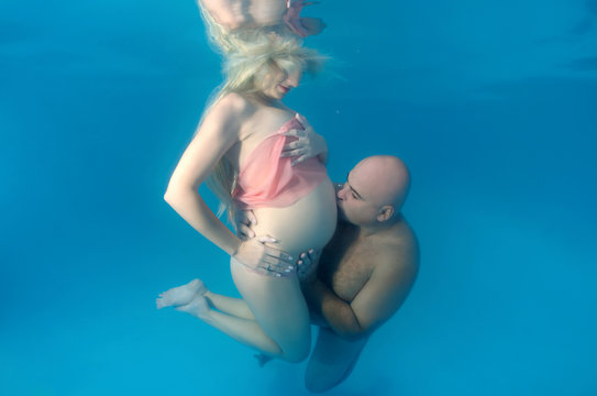 Pregnant Woman And Man In The Pool