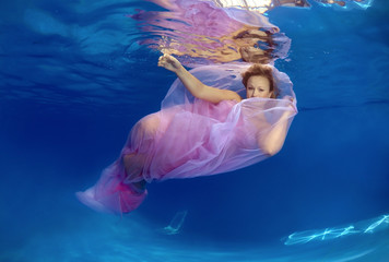  Woman presenting underwater fashion in pool