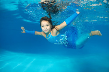 Girl presenting underwater fashion in pool