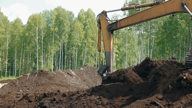 An excavator is loading the ground with a bucket